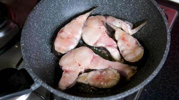 fry catfish fillets Housewife's hands are in the process of frying catfish which has been seasoned and put in a pan filled with hot oil, frying catfish becomes dry and crispy in boiling oil video