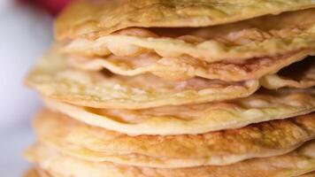 A stack of layers cakes for caramel cake on cooling rack. stack of cake layers spreads cream on the cake layers. Stacks layers one on top of the other. Nearby ingredients for making the cake video