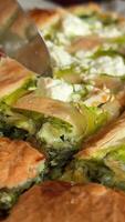 spinach pie girl with red manicure cuts a piece of pie with a knife Delicious Spinach and Feta Pie on Rustic Wooden Table video