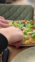 pizza with herbs Lettuce, tomatoes, cheese Delicious Pizza Caesar with Parmesan cheese on wooden table while pouring sauce video
