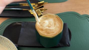 woman sitting in cafe at table, reading news, conducting interviews, online webinars on tablet with green screen. Stirring coffee, cappuccino or latte video