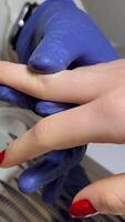 Close-Up of Manicurist Applying Bright Red Nail Polish to Womans Nails on Blue Towel, Gloved Hands Creating Detailed Professional Manicure with Intense Color Contrast video