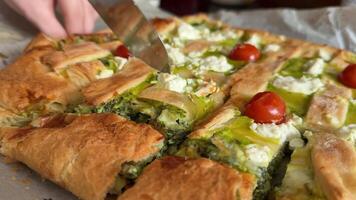 spinach pie girl with red manicure cuts a piece of pie with a knife Delicious Spinach and Feta Pie on Rustic Wooden Table video