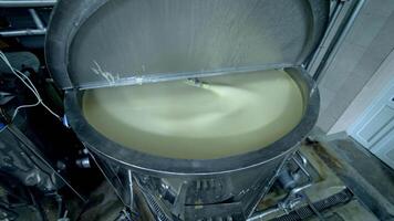 Big cistern with automatic mixing system inside. Beating the butter in automatic mixer tank. Butter production at milk factory close up. video