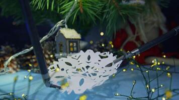 Robotic manipulators for microsurgery hold and stretch the paper snowflake. Christmas tree and ornaments at the backdrop in blur. Close up. video