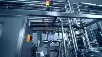 Technological equipment for dairy products manufacturing. Complicated system of pipes intertwining with each other and leading to the cisterns. Close up with gradual distancing. video
