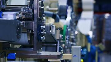Automated mechanisms working harmoniously at the factory producing diapers. Conveyor line passing nappies side view. video