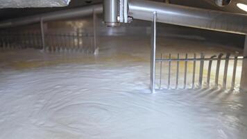 Two big automatic nozzles turning and mixing the dairy product. Fermented milk being mixed up in a big tank. Butter and cheese manufacturing at modern plant. video