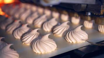 Creamy marshmallows being squeezed onto the conveyor belt. Well-coordinated work of the molding machine producing tasty sweets. Process in close up. video
