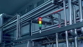 Signaling lights among the pipelines at milk factory. The flashlight with red, yellow and green lights. Red and yellow lights are on. video