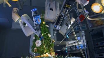 Fantastic work of innovative surgical equipment to decorate New Year tree. Da Vinci robotic arms moving and decorating Christmas tree on the operating table. View from below. video