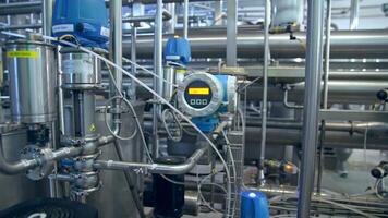 Pipelines and tanks with adjusted appliences and devices. Complicated automatic apparatus for producing dairy products. Close up with gradual distancing. video