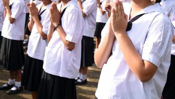 A group of children are praying in a line photo