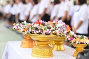 A table with a gold vase and a bunch of flowers photo