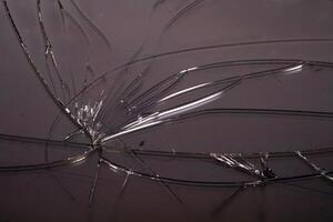 Intricate patterns formed by cracks on a dark surface in natural light photo