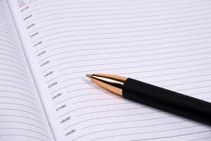 Scheduling tasks with a pen on a blank planner page photo