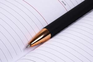 Modern pen resting on an open notebook with lined pages photo