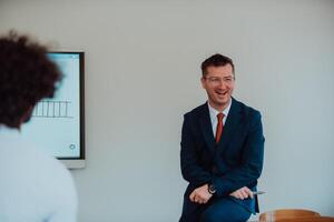 A modernly dressed professor engages in educating students, who listen attentively, creating a dynamic scene of knowledge-sharing and focused learning in the classroom. photo