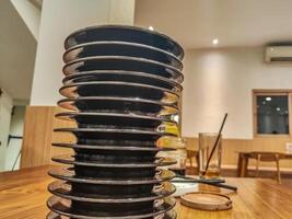 pile of plates of leftover sushi food in a Japanese restaurant with an all you can eat or buffet concept and Kaitenzushi or moving conveyor sushi. photo