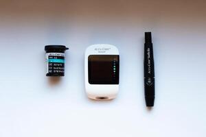 Poznan, Poland - 10.20.2022 Accu-Chek Instant glucose meter with test strips and finger piercing device photo