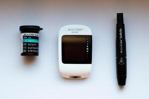 Poznan, Poland - 10.20.2022 Accu-Chek Instant glucose meter with test strips and finger piercing device photo