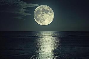 Full Moon Rising Over Calm Ocean with Silvery Reflection on Water photo