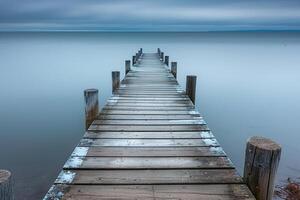 Wooden Pier Stretching into Calm Ocean Waters in Nature Background photo