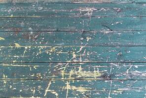Old wooden surface with rough, worn texture and peeling green paint, horizontal planks with deep scratches highlighting the natural vintage texture of the wood photo