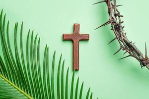 Palm Sunday greeting card. Thorn crown, wooden cross and palm leaf photo