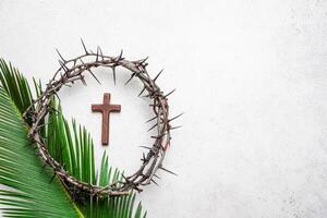 Palm Sunday. Crown of thorns, cristian cross on palm leaf photo