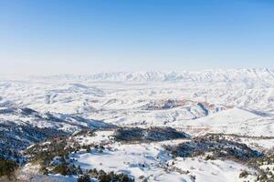 Beautiful winter panorama of the Tien Shan mountains in Uzbekistan in the Beldersay ski resort on a clear winter day photo