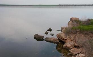 Coast with rocks in the water, Hadzhibey estuary. Reflection in water photo