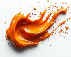 Bold fiery periperi sauce splashed onto a white background with a spoon beside it photo
