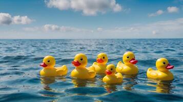 Yellow toy rubber ducks floating on the surface of the ocean photo