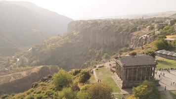 Aerial revealing view visitors by The Garni Temple - classical colonnaded structure in the village of Garni. Pagan temple.Symbol of pre-Christian Armenia.Ancient greek roman style landmark video