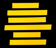 Top view set of yellow adhesive vinyl tape or cloth tape in stripes shape in straight lines isolated on black background with clipping path photo