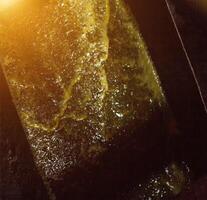 Production of rapeseed oil, output of rapeseed oil from the press to the storage tank, close-up. rape oil photo
