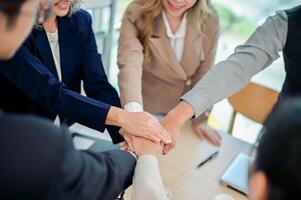 A close-up of businesspeople's hands coming together in a teamwork gesture, celebrating success. photo