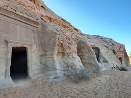 A beautiful view of the caves built into the mountains at the archaeological site of Hegra in Madain Saleh, AlUla in Saudi Arabia. photo