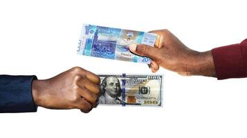 Kuwaiti Dinar USA Dollar currrency pairing.Black African hands holding and comparing two bank notes. Dollar versus Dinar . Weighing Currencies against each other. Exchange rate photo