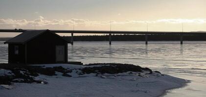 Backlit image of fishing hut and bridge at Lake Storsjon in Jamtland, Sweden photo