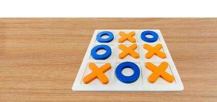 A game of Tic-Tac-To on a wooden table for fun entertainment. photo