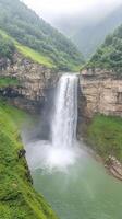 Majestic Jogini Waterfall in Lush Green Valley Surrounded by Misty Mountains and Cliffs in 4K Vertical photo