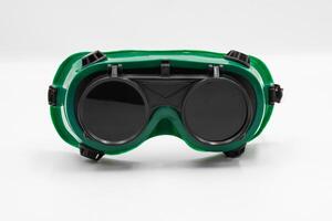 Close-up front view of welding goggle designed for protection during welding, featuring a green frame and heavy duty lenses photo