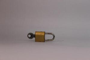 A small padlock on a white surface. photo