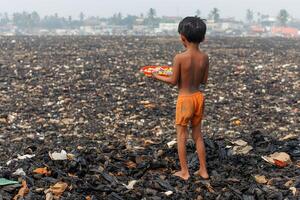 A child gathering plastic waste in a garbage dump, emphasizing the impact of pollution and the need for environmental action photo