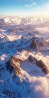 Snowy mountain peaks rise above fluffy clouds at sunset photo