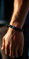 Close-up of a hand wearing a beaded bracelet made of stones photo