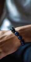 Stylish black bead bracelet worn on a person's wrist photo