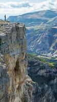A person standing on a cliff photo